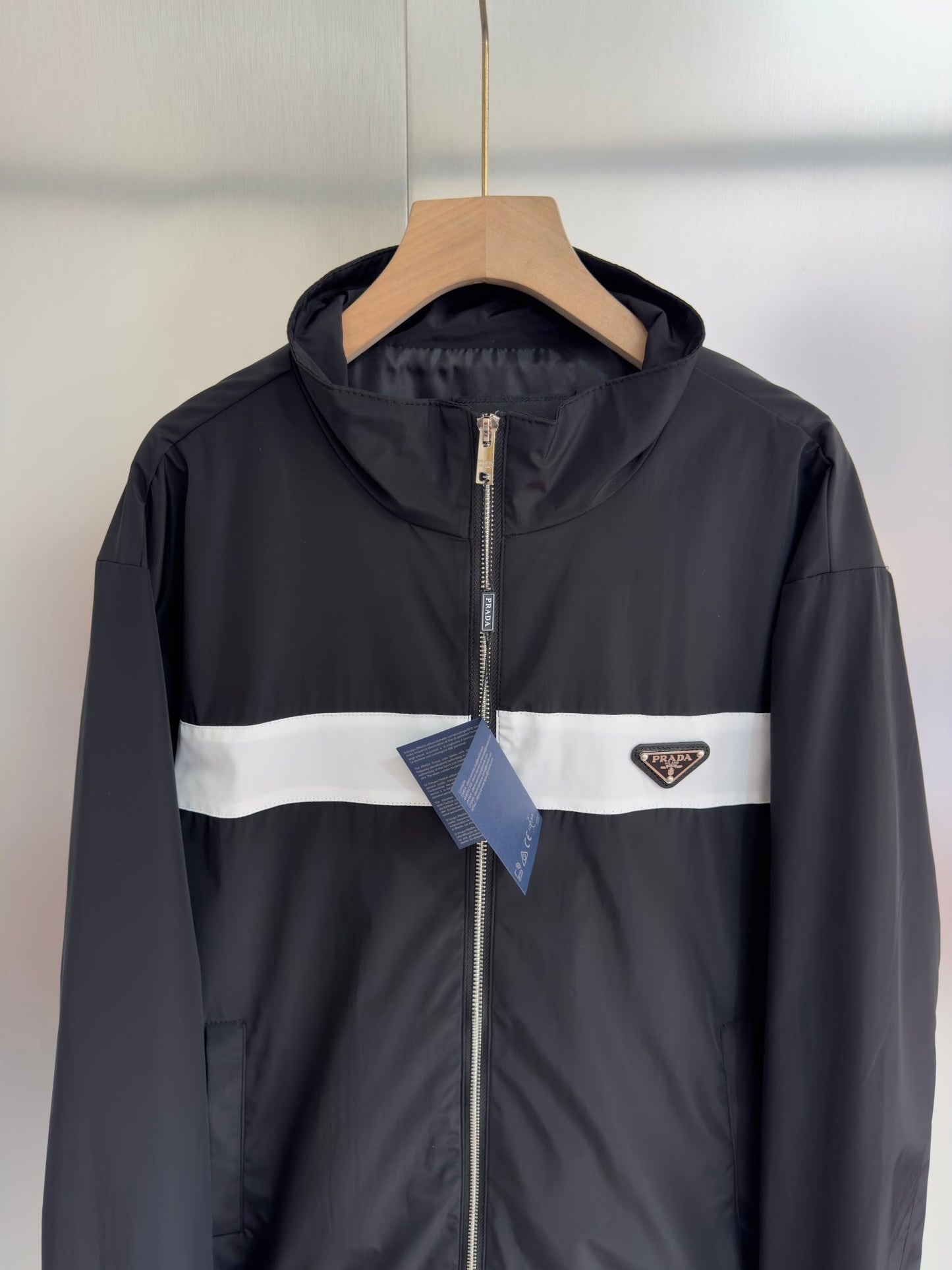 Chaqueta con logo metálico triangular.