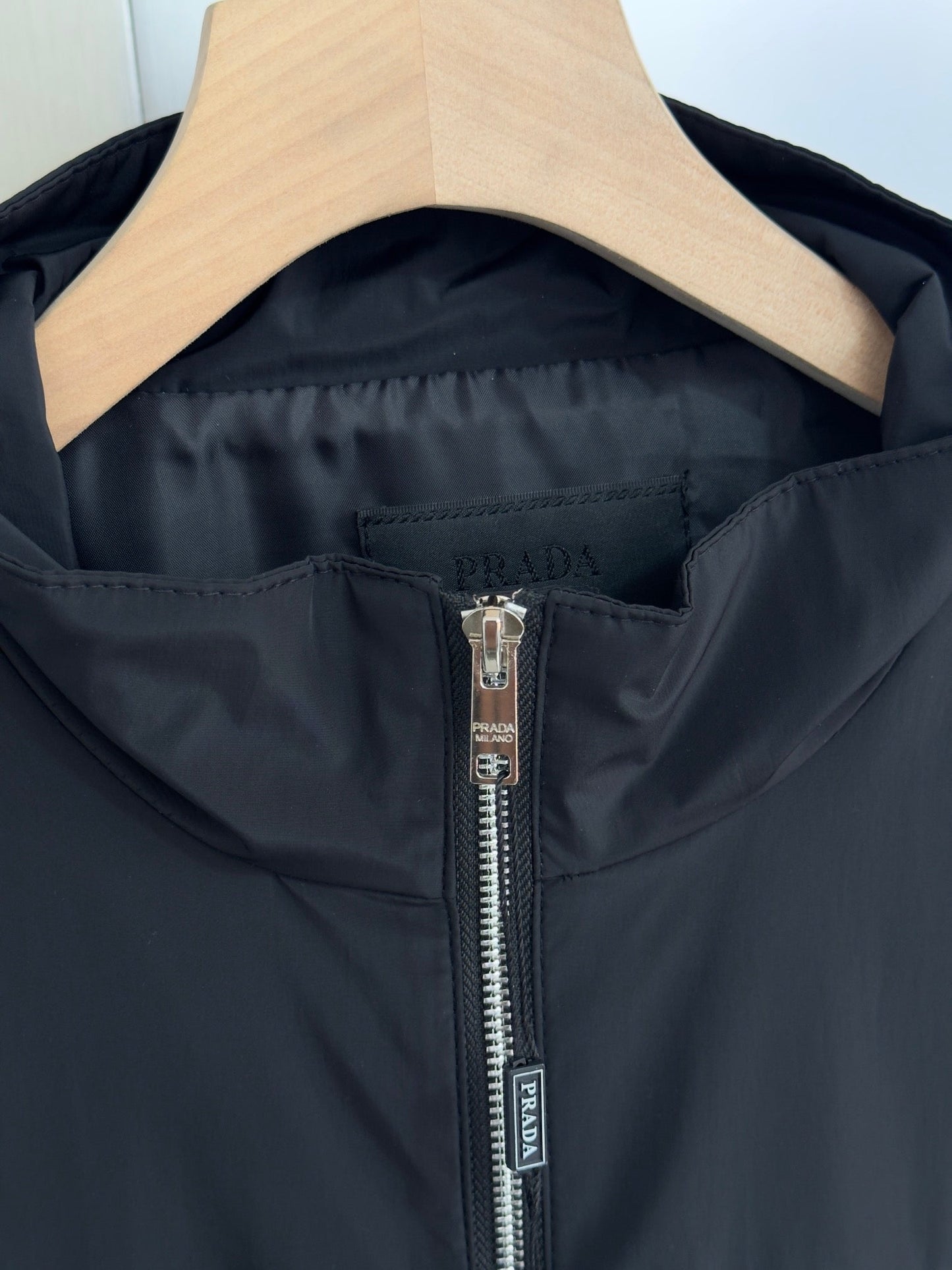 Chaqueta con logo metálico triangular.