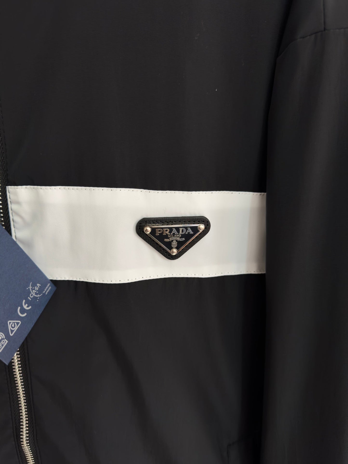 Chaqueta con logo metálico triangular.